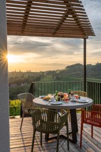 a table and chairs on a deck with the sunset at steiRerBLiCke - Weinstöckl Steinbach in Steinbach