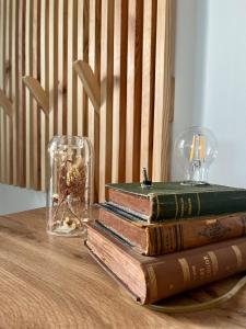 a stack of books on a table with a glass vase at Berkenye 2621 in Kismaros
