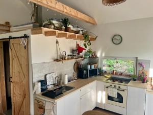 a kitchen with white cabinets and a sink and a stove at Berkenye 2621 in Kismaros