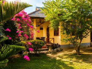 a yellow house with pink flowers in front of it at Röstiland by NOXAMA SAMUI in Lamai