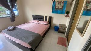a bedroom with a bed with pink sheets and a mirror at Hotel O D Mama Chalet in Jeniang