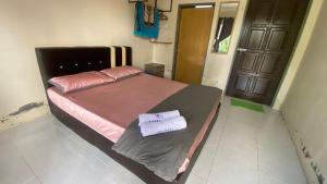 a bedroom with a bed with two towels on it at Hotel O D Mama Chalet in Jeniang