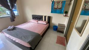 a bedroom with a bed with pink sheets and a mirror at Hotel O D Mama Chalet in Jeniang