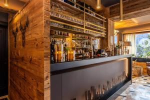 eine Bar mit einer Holzwand in der Unterkunft Hotel Folgarida in Folgarida