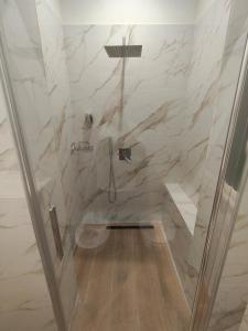 a bathroom with a shower with marble walls at Domus Rhegium in Reggio di Calabria