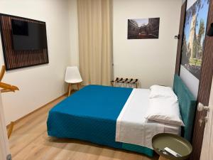 a bedroom with a blue and white bed and a television at Domus Rhegium in Reggio di Calabria