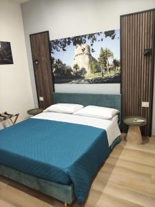 a bedroom with a blue bed with a picture on the wall at Domus Rhegium in Reggio di Calabria