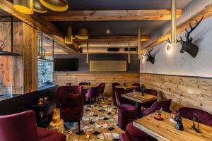 ein Restaurant mit Holzwänden und lila Stühlen und Tischen in der Unterkunft Hotel Folgarida in Folgarida + 236 Fotos