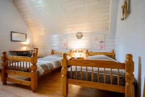 two twin beds in a room with wooden walls at Chambres d'hôtes, Les Combes in Orbey