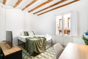 a white living room with a bed and a tv at weroomies - Pons Icar H3 in Tarragona
