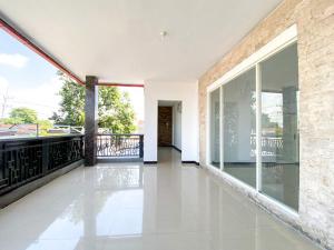 an empty house with glass doors and a balcony at Urbanview Bangsal Mojokerto in Ngranggon