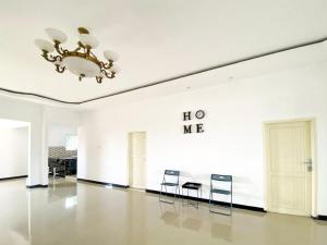 a large white room with chairs and a chandelier at Urbanview Bangsal Mojokerto in Ngranggon