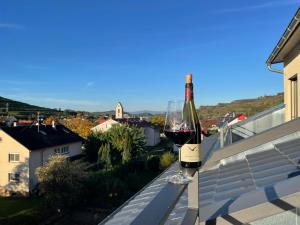 a glass of wine sitting on the ledge of a house at Apartment Steinkauz in Vogtsburg
