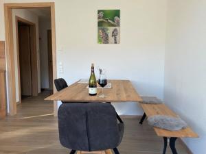 a wooden table with two bottles of wine on it at Apartment Steinkauz in Vogtsburg