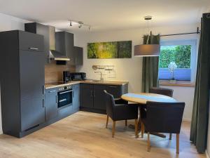 a kitchen with a table and a dining room at Ferienwohnung Haus Hahnfelsblick in Erfweiler
