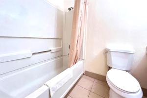a bathroom with a toilet and a bath tub at Carquinez Inn Vallejo I 80 Near Napa Valley in Vallejo +17 photos