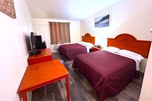 a hotel room with two beds and a television at Carquinez Inn Vallejo I 80 Near Napa Valley in Vallejo