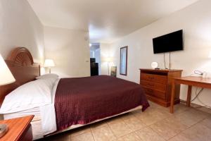 a hotel room with a bed and a flat screen tv at Carquinez Inn Vallejo I 80 Near Napa Valley in Vallejo