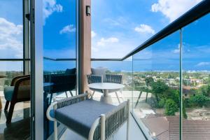 a balcony with a table and chairs and glass windows at Abantu Hotel in Dar es Salaam