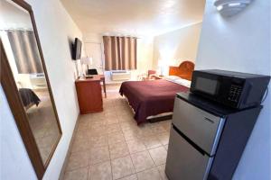 a small hotel room with a bed and a television at Carquinez Inn Vallejo I 80 Near Napa Valley in Vallejo