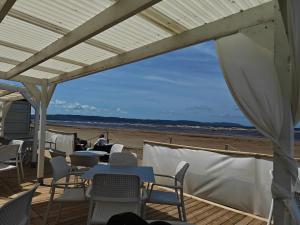 a group of tables and chairs on the beach at Enkelt nära havet in Skummeslövsstrand