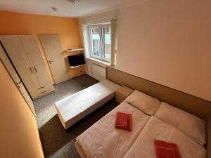 a small bedroom with a bed and a window at Penzion U Bártů, Dešov in Desov