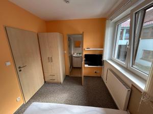 a room with orange walls and a bathroom with a mirror at Penzion U Bártů, Dešov in Desov
