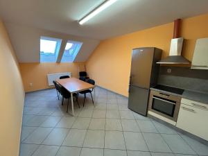 a kitchen with a table and a refrigerator at Penzion U Bártů, Dešov in Desov