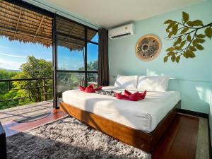 a bedroom with a bed with red pillows on it at Phi Phi Sea Sky Resort in Phi Phi Islands