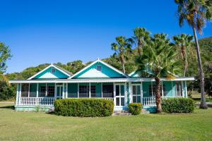 a green house with palm trees in front of it at Oualie Beach Resort in Nevis