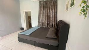 a bed sitting in a room with a window at Hotel O D Longan Cottage in Kampung Tikam Batu