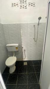 a bathroom with a toilet and a shower at Hotel O D Longan Cottage in Kampung Tikam Batu