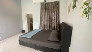 a bed sitting in a room with a window at Hotel O D Longan Cottage in Kampung Tikam Batu +2 photos