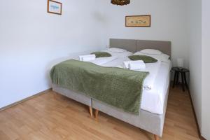 a bedroom with a bed with a green blanket on it at OÁZIS Hotel*** in Nagykanizsa +115 photos