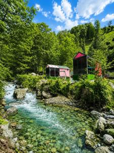 a stream with two huts next to a forest at Eça River Bungalov in Ayder Yaylasi +52 photos