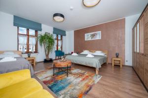 ein Hotelzimmer mit zwei Betten und einer Couch in der Unterkunft Hotel Korek in Frýdek-Místek