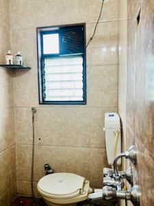 a bathroom with a toilet and a window at Wakad Executive in Méribel Village