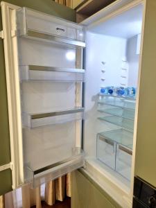 an empty refrigerator with its door open at Dream Luxury Suite in Tirana