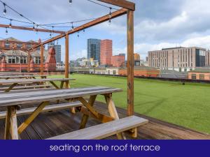 a group of picnic tables sitting on a roof terrace at NQnap in Manchester