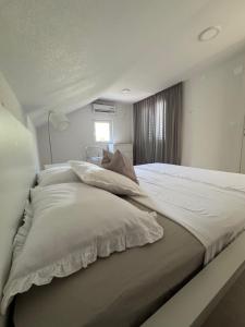 a bedroom with a large bed with white sheets and pillows at Adriatic Retreat Mljet in Polače