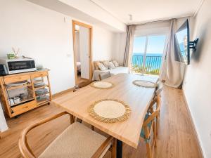 a dining room with a table and a view of the ocean at Frente al mar , Piscina ,Playa in El Campello