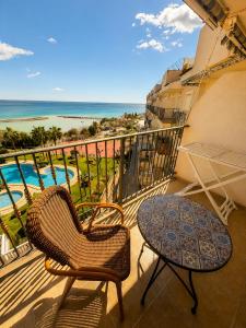 a balcony with a table and chairs and the ocean at Frente al mar , Piscina ,Playa in El Campello
