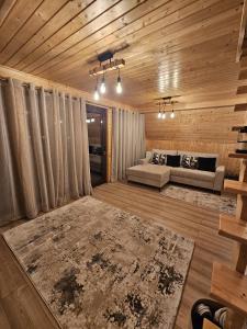 a living room with a couch and a rug at Plai cu dor - Brebu in Brebu Mînăstirei
