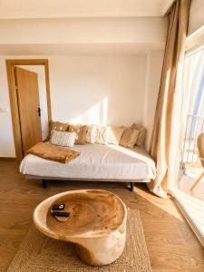 a living room with a couch and a wooden coffee table at Frente al mar , Piscina ,Playa in El Campello
