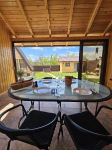 a glass table with two chairs in a patio at Plai cu dor - Brebu in Brebu Mînăstirei