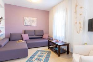 a living room with a couch and a table at Alex port view apartments in Syvota