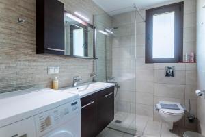 a bathroom with a sink and a washing machine at Alex port view apartments in Syvota +34 photos