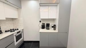 a kitchen with white cabinets and a coffee maker on a counter at Villa Guru Efeler in Didim