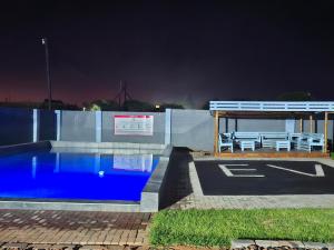 a swimming pool with a bench and a picnic table at Eden Villas Guesthouse in Kuruman