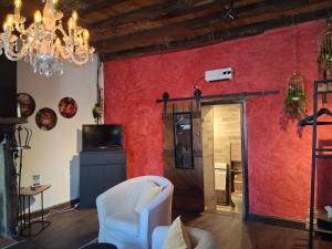 a living room with red walls and a chandelier at B&B maison du Saint Cirque in Saint-Dau